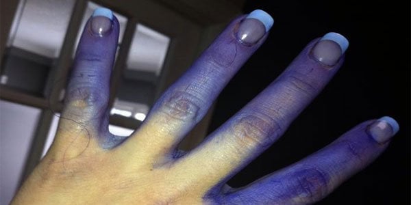 Chica con las manos llenas de pintura azul 