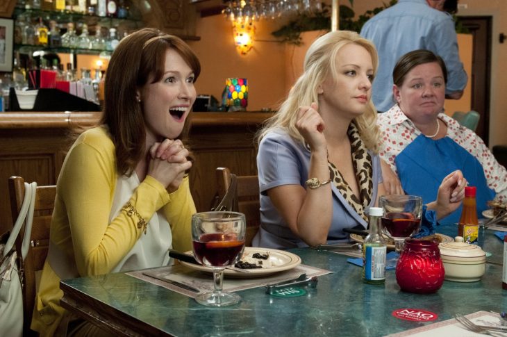 Chicas en una reunión de comida con la cara de aburrimiento 