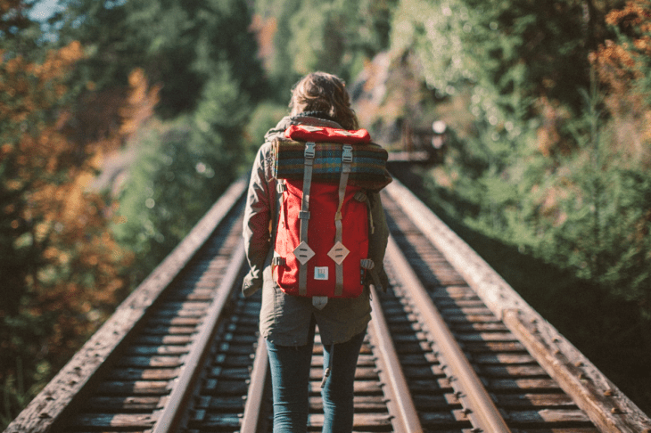 Chica caminando en unas vías del tren 