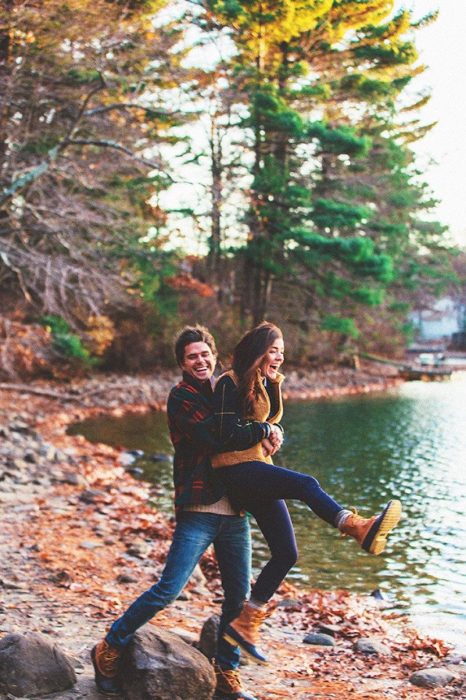 Pareja de novios disfrutando de una puesta de sol en un lago