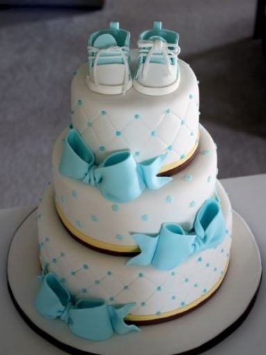 pastel con moños color azul y unos zapatos de color azul y blanco en la parte superior 