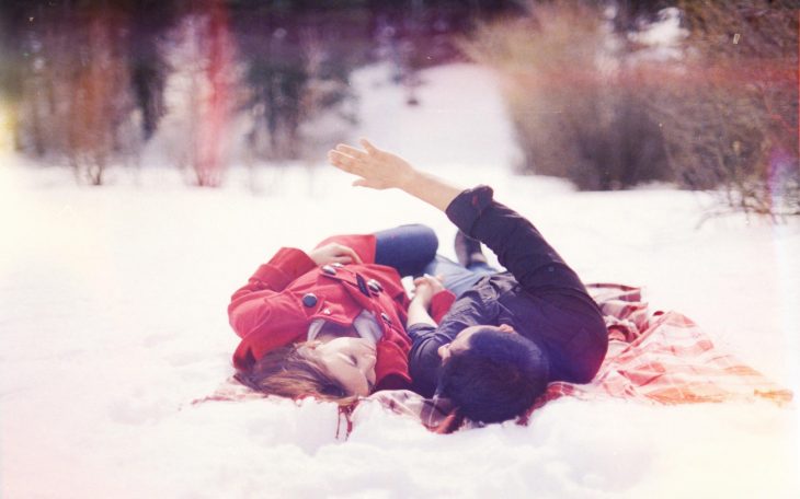 Pareja de novios acostados en la nieve 