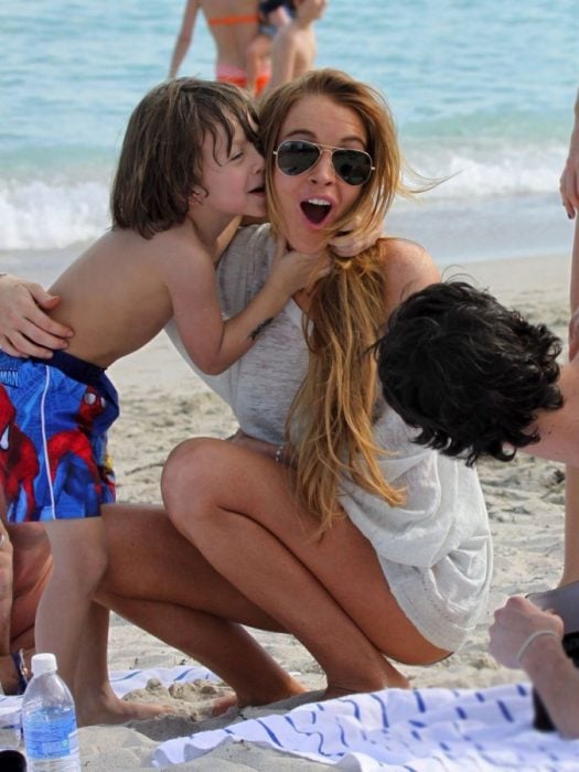 Niño besando a una chica en la playa 