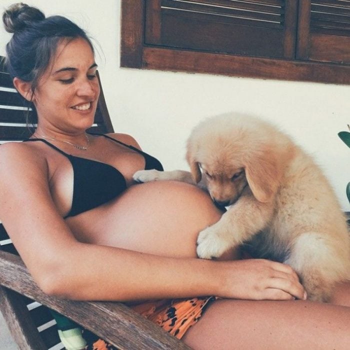 mujer embarazada con su perro sobre la panza 