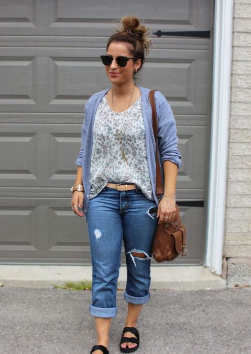 Chica usando pantalones rasgados camisa suéter morado y bolsa 