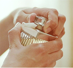 GIF mujer aplicandose perfume en las muñecas y cuello 