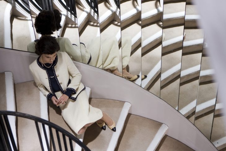 Escena de la película coco before chanel Audrey Tautou sentada en unas escaleras 