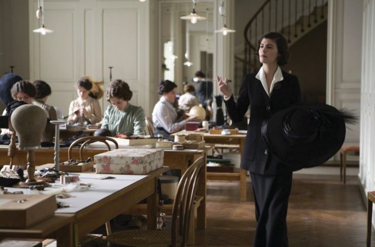 Escena de la película coco before chanel actriz audrey tatou caminando por una casa de costureras mientras fuma 