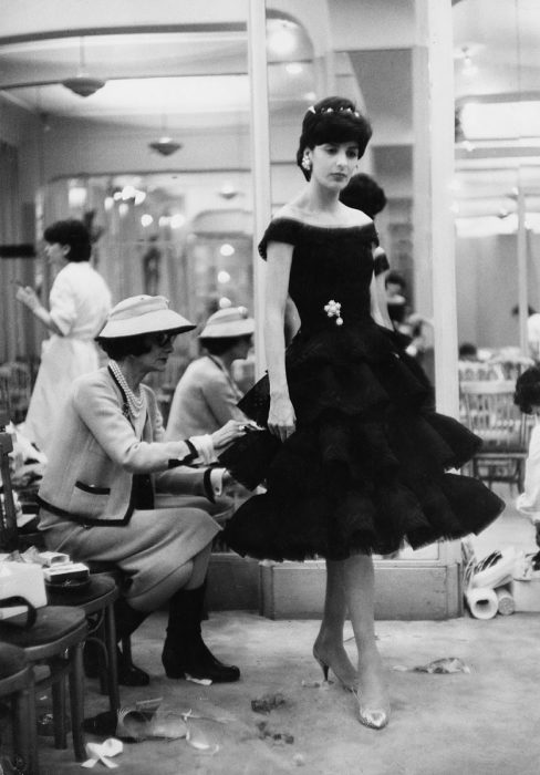 Diseñadora de modas coco chanel cociendo el vestido de una modelo 