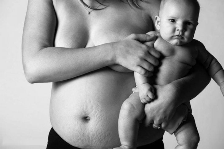 muje embarazada cargando a un bebé en brazos