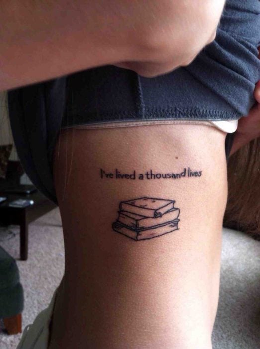 chica con un tatuaje con frases y libros puesto en el costado de su cuerpo 
