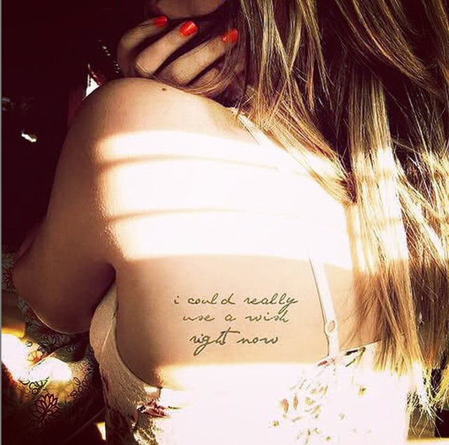 tatuaje de frase en la espalada de una chica a la que le da el sol 