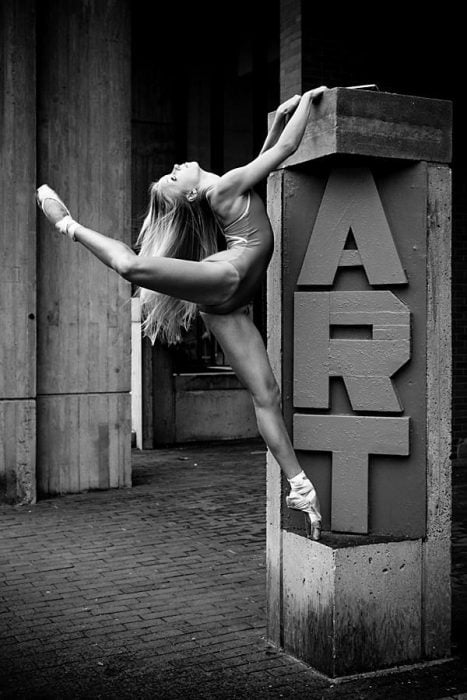 bailarina de ballet parada sobre una estructura que dice arte