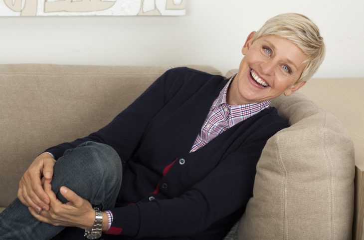 Conductora de televisión Ellen deGeneres sentada en un sofá riendo 