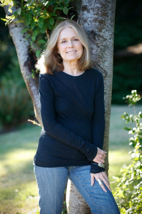 Periodista y escritora estadounidense Golria Steinem recargada sobre un árbol posando para una foto 