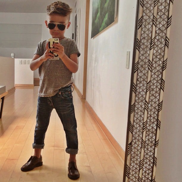 Niño parado frente a un espejo tomándose una selfie 