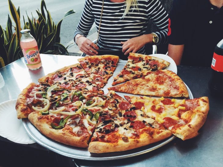 Chica frente a una gran pizza 