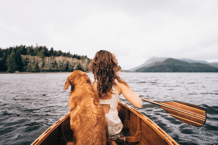 Chica en una canoa con su perro 