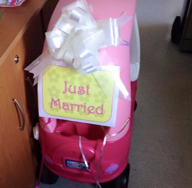 Carro de juguete con un moño y un letrero que dice recién casados 