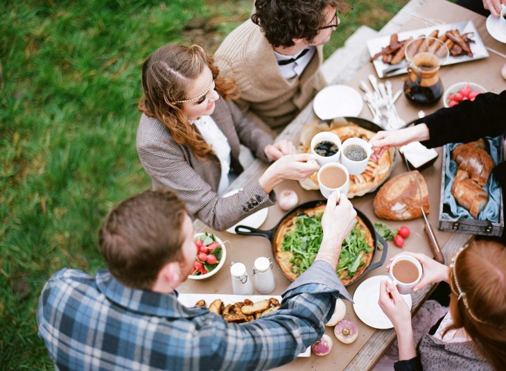 Reunion familiar de personas que estan desayunando en el jardín de una casa 