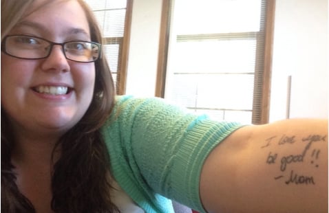 Chica mostrando su tatuaje que es una nota de su mampa 