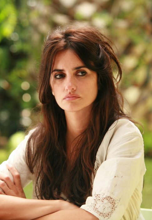 Penelope cruz con los brazos crusados puestos sobre una mesa pensando 