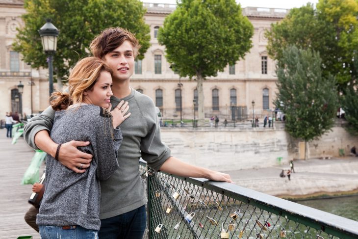 Escena de la película LOL con miley cyrus chicos abrazados en el puente mientras miran la ciudad 