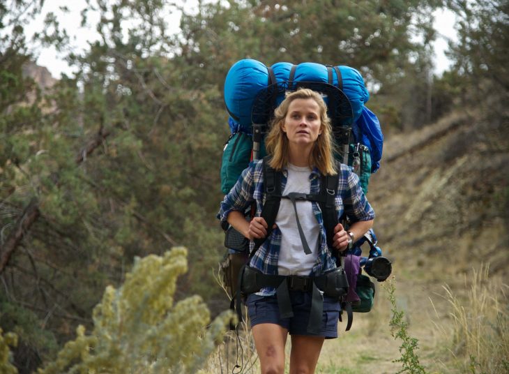 Escena de la película wild resse whiterspon con una mochila en sus espaldas caminando por un sendero 