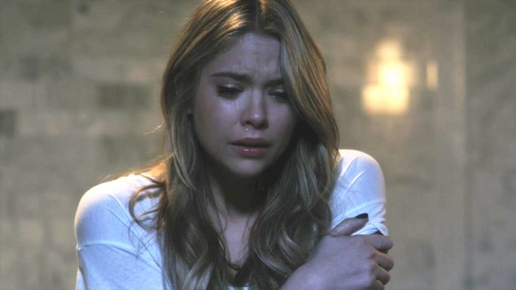 Hanna de la serie pretty little liars llorando mientras está frente a la ventana de su cuarto 