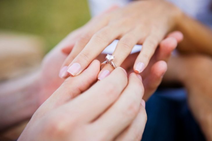 Pareja colocando el anillo de compromiso 