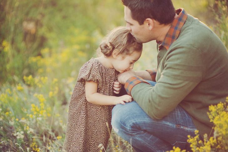 papá besando a su pequeña hija en la frente 