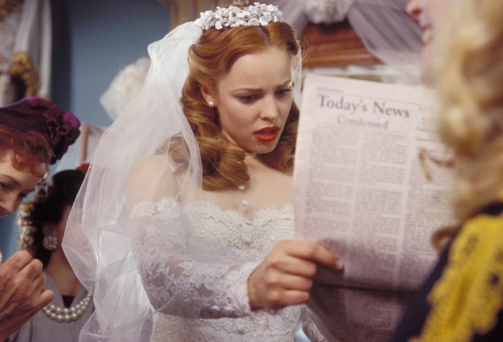 Escena de la película el diario de noah, allie leyendo un periódico mientras tiene un vestido de novia puesto 