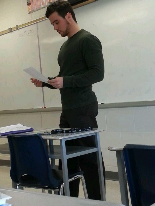 Profesor sexy leyendo una hoja en clase 