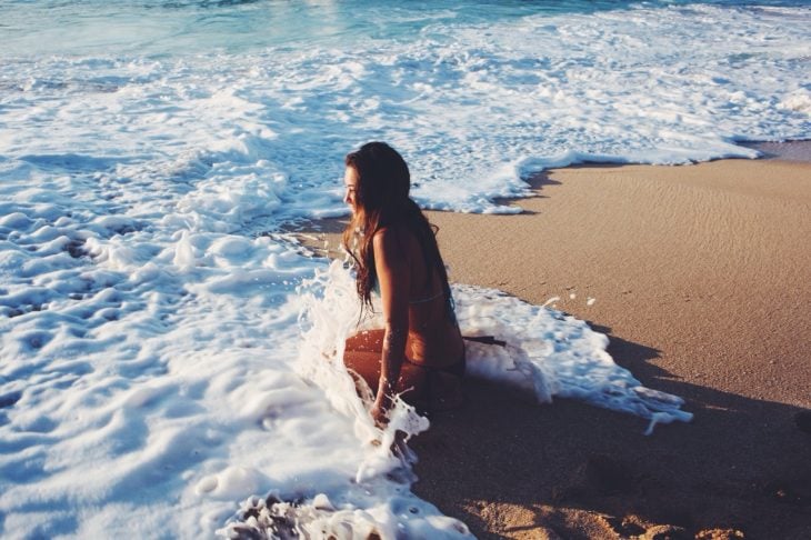 Chica disfrutando de las olas del mar