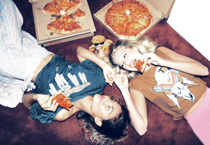 Chica comiendo pizza acostadas 