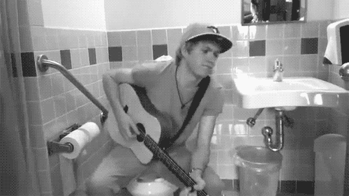 Chico tocando guitarra eléctrica en el baño