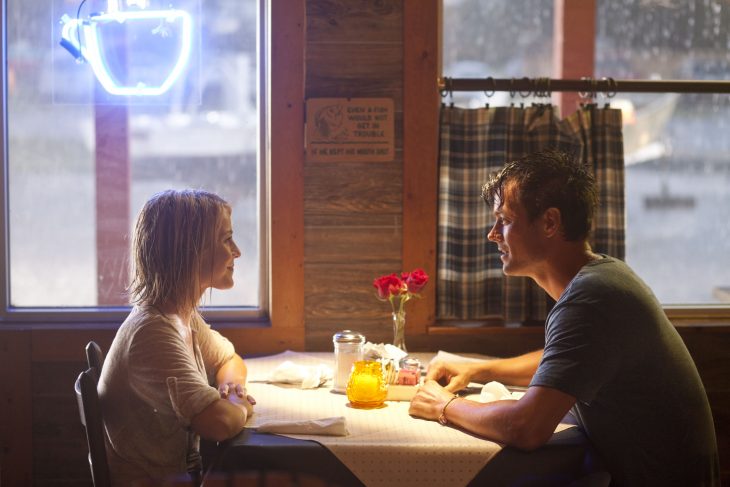 Escena de la película Safe Haven protagonistas hablando mientras estan sentados frente a un mesa hablando 