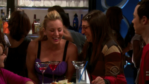GIF chicas de la serie la theoria del big bang bebiendo en un bar 