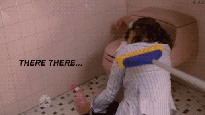 GIF. chica vomitando en un baño mientras otra le da palmadas en la espalda con una escoba 