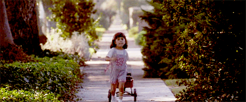 GIF niña de la película matilda jalando un carro con libros de la biblioteca