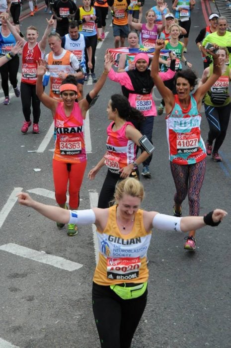Mujer corriendo un maratón al lado de sus compañeras 