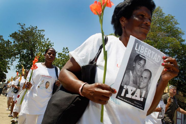 mujer de la organización las damas de blanco caminando por la calle exigiendo justicia 