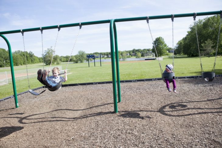 Niños jugando en los columpios en un parque 