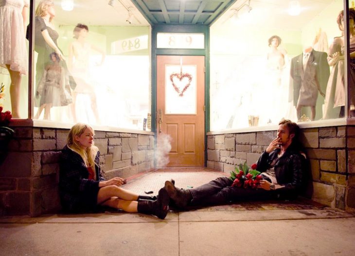 Escena de la película blue valentine pareja fumando afuera de una tienda