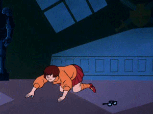 GIF. vilma de la caricatura scooby doo buscando sus lentes en el suelo 
