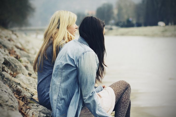 Amigas sentadas en unas piedras