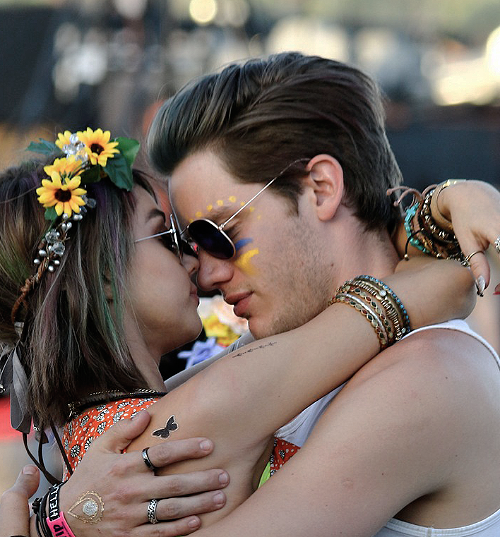 Chica besando a un chico mientras están en el festival de música de coachella 