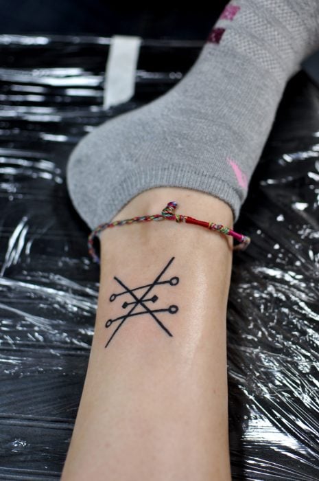 Chica con un tatuaje de alquimia en su pie 