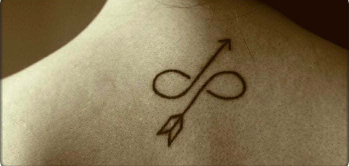 Tatuaje en la espalda de una chica de flechas formando un infinito 