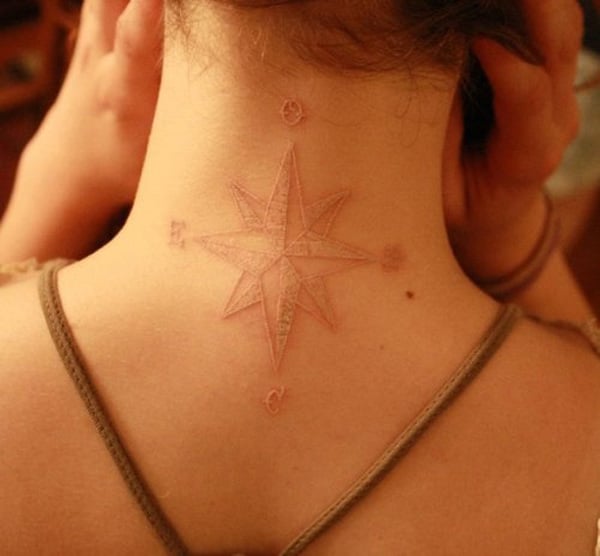 Tatuaje de tinta blanca en forma de rosa de los vientos puesto en el cuello 